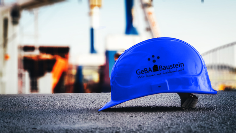 Blauer Sicherheitshelm mit dem Logo der GeBA Baustein GmbH