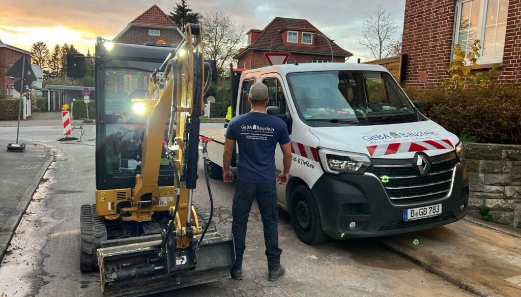 Tief- und Strassenbau mit Fahrzeugen der GeBA Baustein GmbH und einem Mitarbeiter im Firmen-Shirt