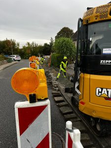 Mitarbeiter und Baufahrzeug der GeBA Baustein GmbH bei Tiefbauarbeiten